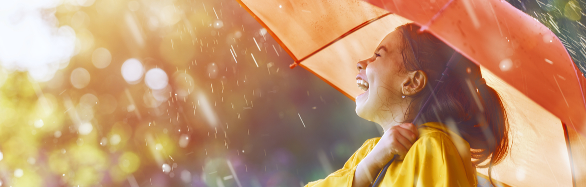 Laughing girl holding an umbrella in the rain
