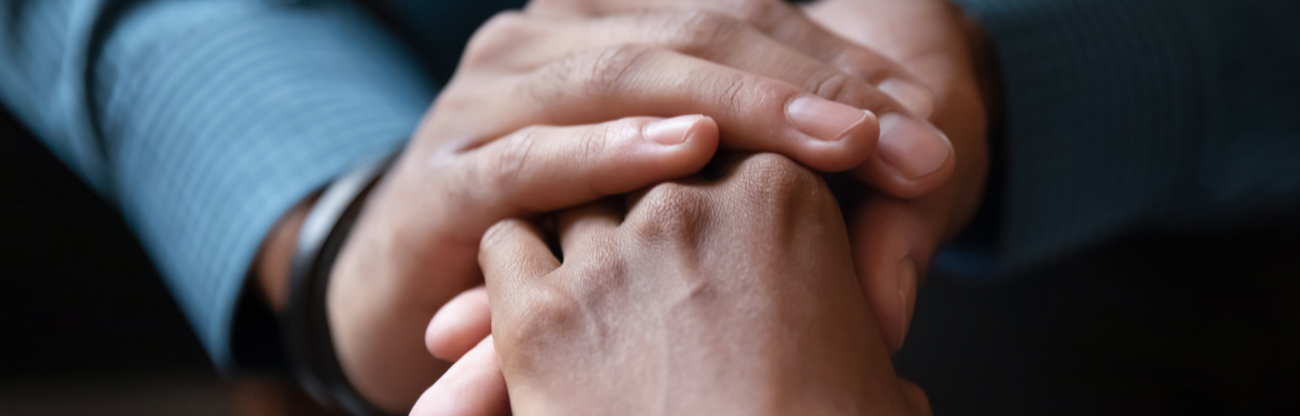 Close-up of two adults holding hands