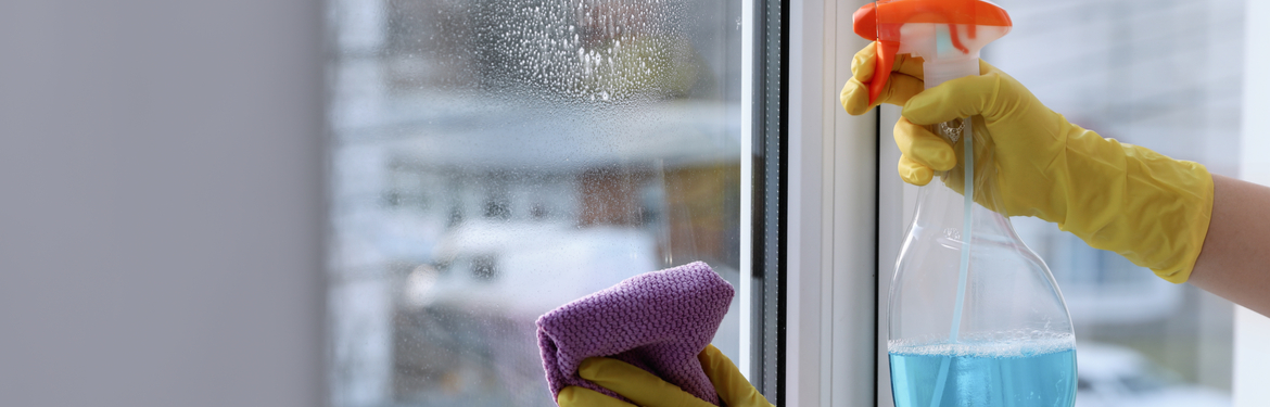 A close-up of someone cleaning windows in their home.