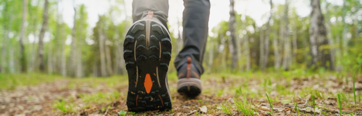 A close-up of a person walking in the woods.