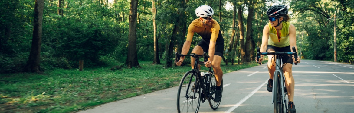 A couple cycling together on a road.
