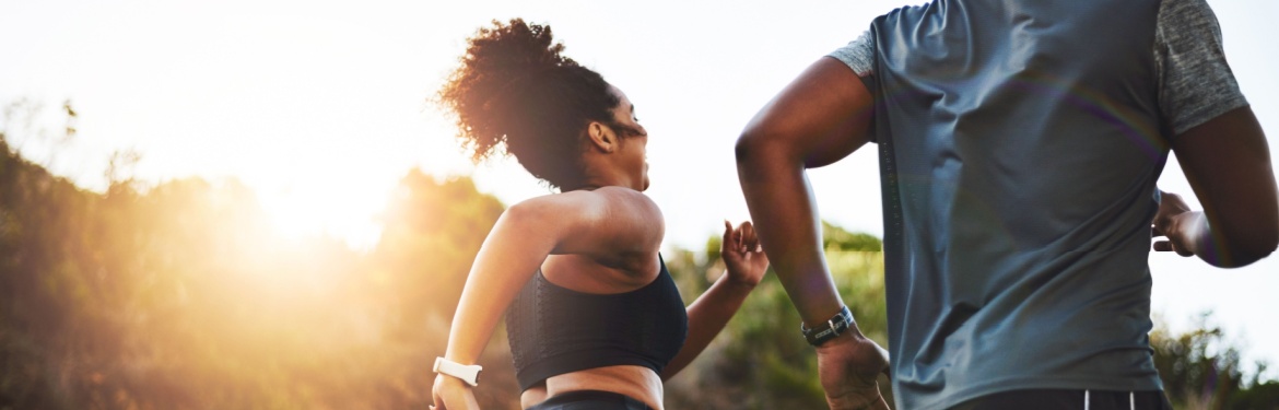 A couple running through a park.