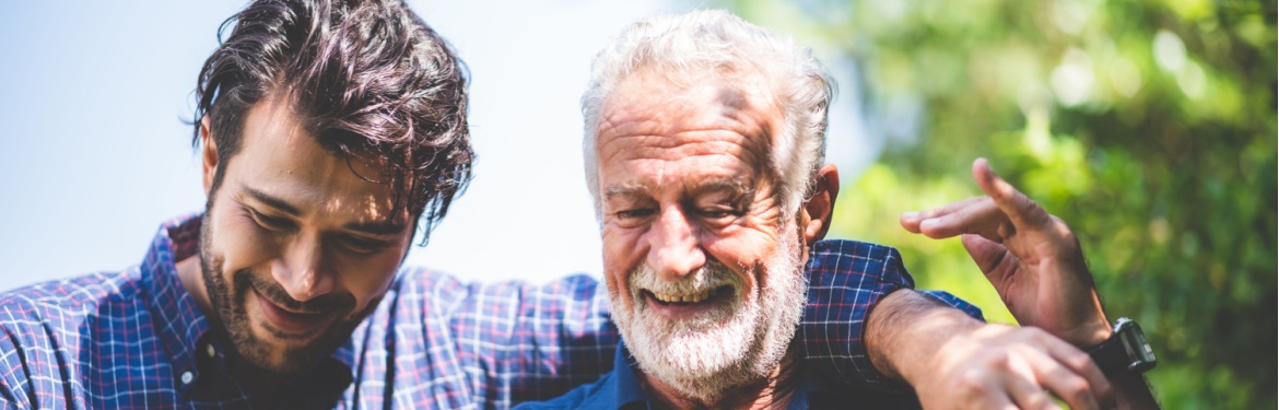A father walking outdoors with his adult son.