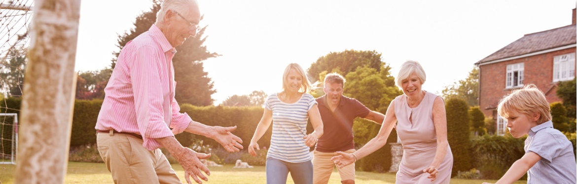 A family playing football in a garden.