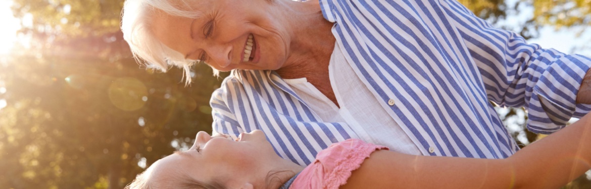 A grandmother playing with her granddaughter outside.
