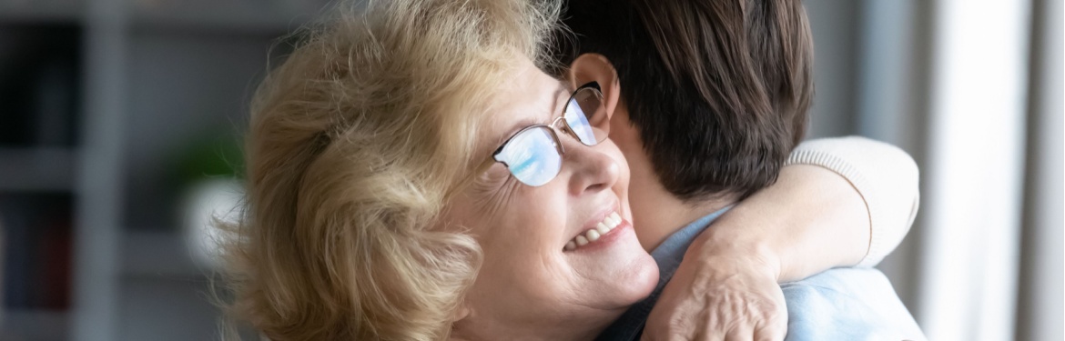 A mother hugging her adult son.
