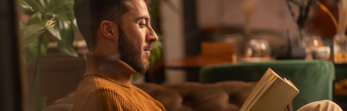 A man reading a book at home.