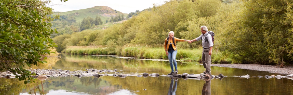 A couple walking across stepping stones.
