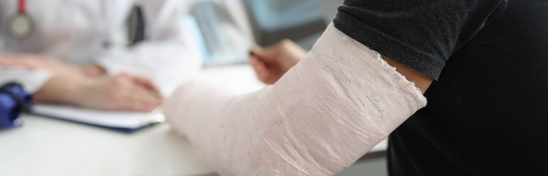 A man with a broken arm speaking with a doctor.