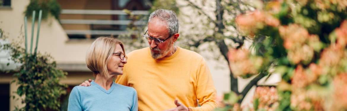 Mature couple walking outside a house