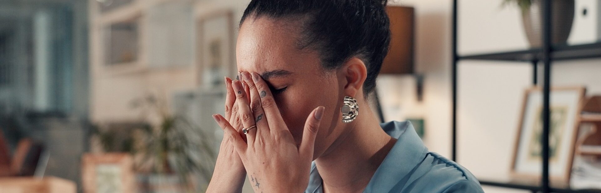A woman sitting at a desk and looking stressed.