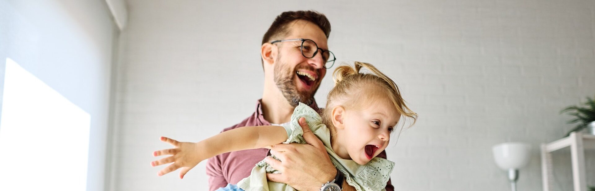 A father playing with his young daughter.