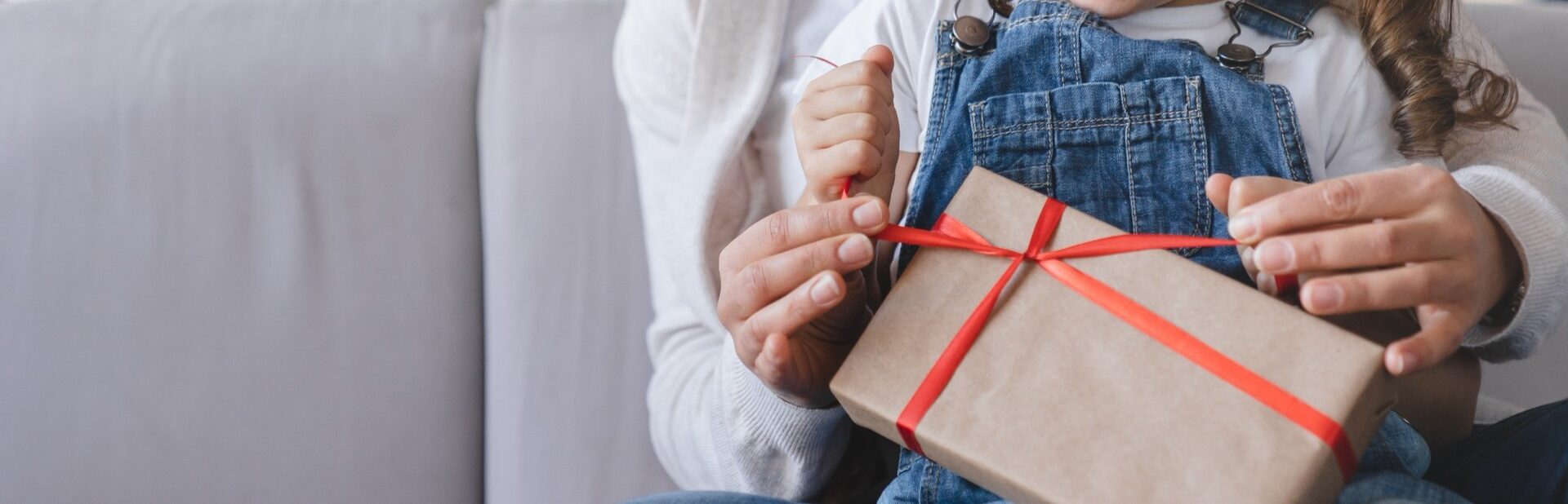 A mother and daughter unwrapping a gift.
