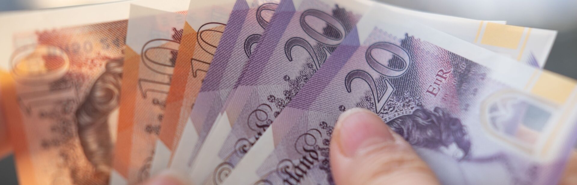 A person holding UK bank notes.